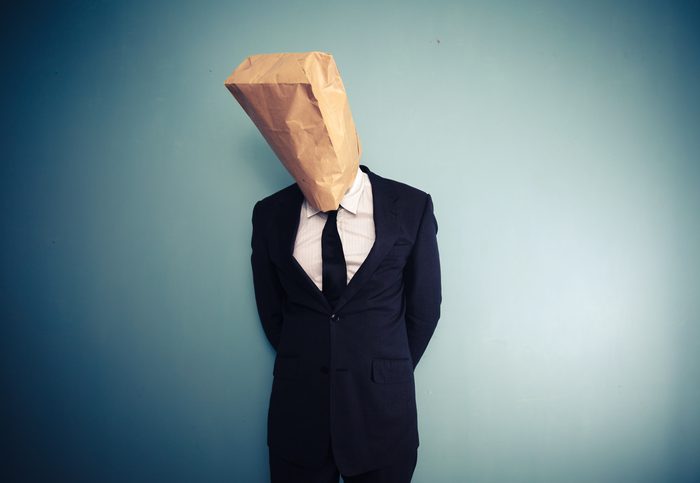 sad and ashamed businessman with bag over head